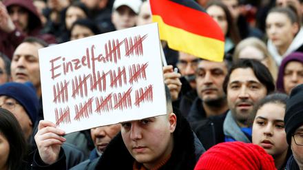 Ein Demonstrant hält in Hanau am Sonntag, 23.2., ein Plakat hoch.
