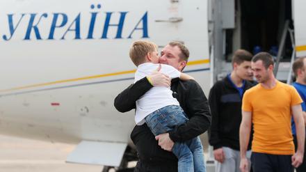 Einer der freigelassenen Ukrainer begrüßt ein Kind auf dem Flughafen in Kiew.