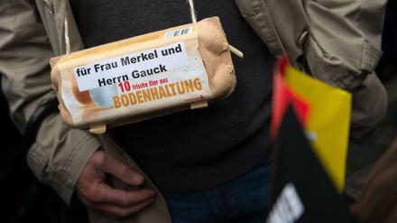 Ein Pegida-Anhänger in Dresden mit einem Eier-Karton - "für Frau Merkel und Herrn Gauck".