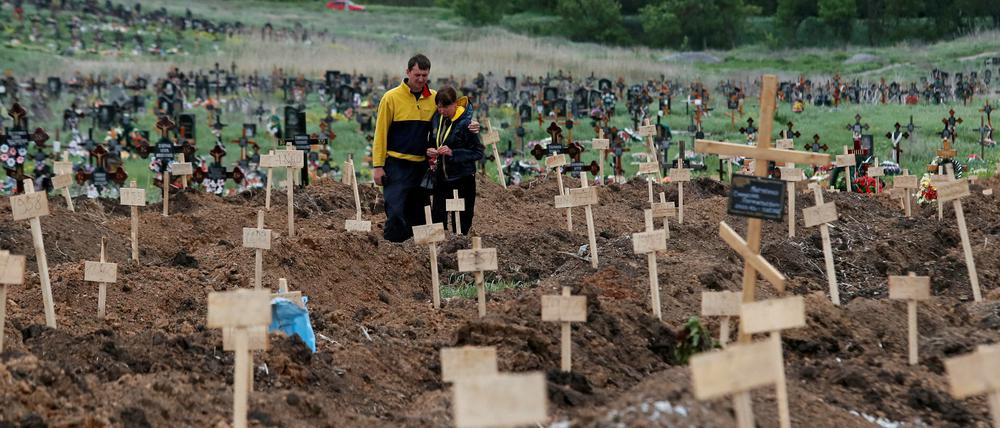 Trauernde auf einem improvisierten Friedhof außerhalb von Mariupol Ende Mai. 