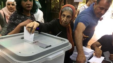 Eine Frau gibt ihren Stimmzettel bei der Parlamentswahl in Syrien ab.