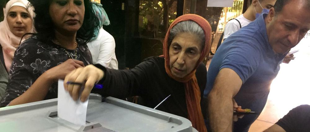 Eine Frau gibt ihren Stimmzettel bei der Parlamentswahl in Syrien ab.