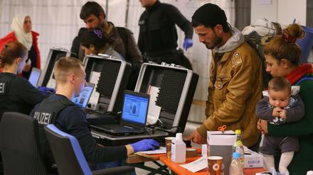 Ankommen, registrieren. Bundespolizisten scannen in einer Sammel- und Verteilungsstelle in Freilassing Fingerabdrücke von gerade eingetroffenen Flüchtlingen. 