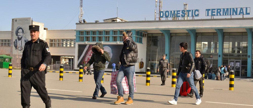 Eine Gruppe junger Männer verlässt am 23.02.2017 in Begleitung eines Polizisten das Flughafengebäude in Kabul, Afghanistan.