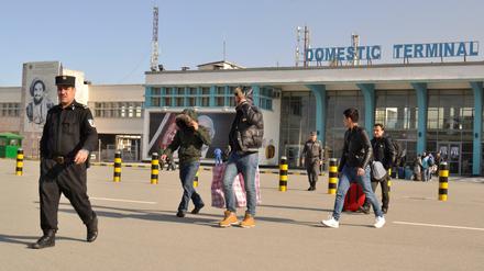 Ein Gruppe junger Männer verlässt im Februar 2017 in Begleitung eines Polizisten das Flughafengebäude in Kabul. 