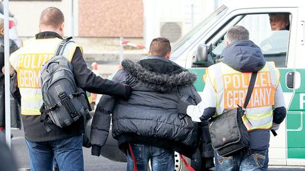 Polizisten begleiten einen Asylbewerber zu seinem Abflug.