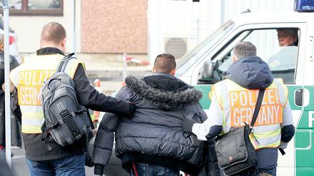 Polizisten begleiten einen Mann, der abgeschoben werden soll (Archivbild).