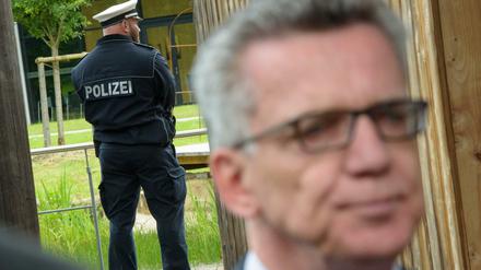 Thomas de Maizière und ein Polizist am Freitag bei der Innenministerkonferenz im Saarland.
