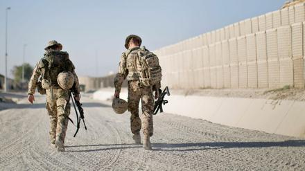 Soldaten der Bundeswehr gehen mit ihrer Ausrüstung durchs Feldlager in Kundus in Afghanistan. Bundesentwicklungsminister Gerd Müller (CSU) hat eine neue Debatte über ihren Abzug eröffnet.