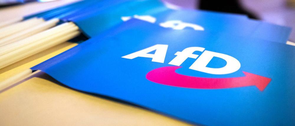 Fähnchen mit dem Logo der AfD liegen bei einem Landesparteitag der AfD auf einem Tisch (Symbolbild). 