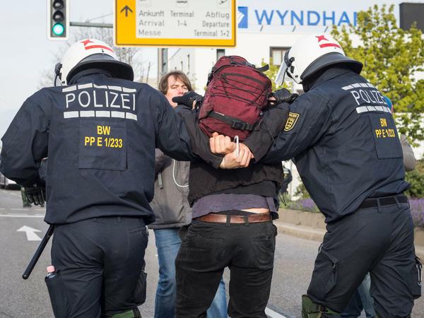Polizisten führen am Rande des AfD-Bundesparteitags in Stuttgart einen Demonstranten ab.