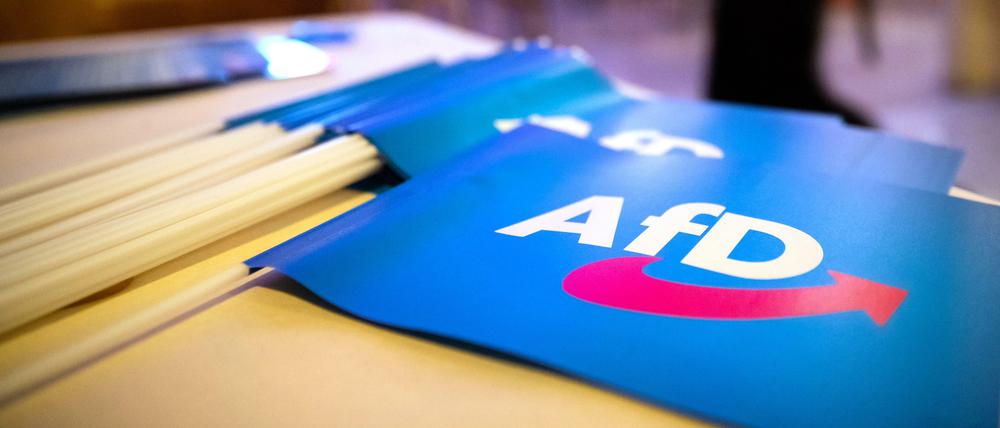 Fähnchen mit dem Logo der AfD liegen auf einem Tisch. 