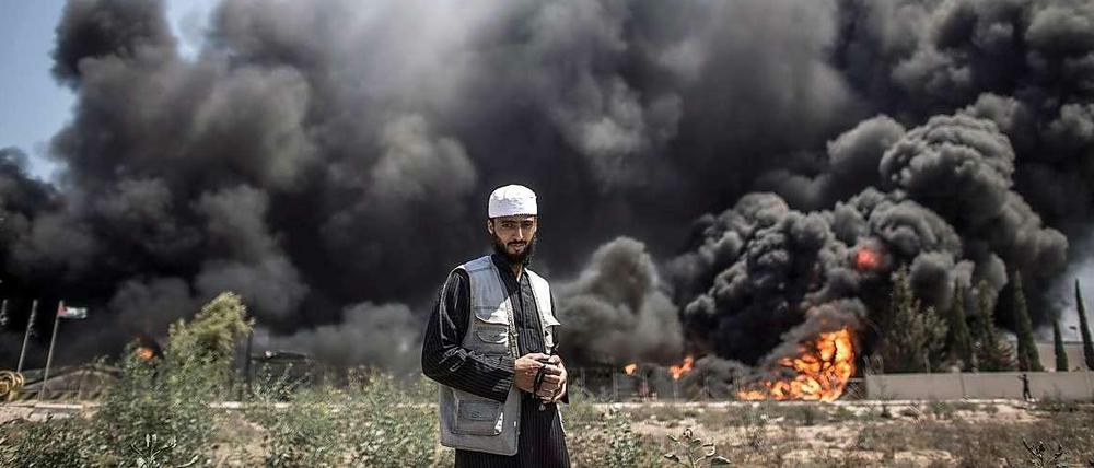 Ein Palästinenser steht vor dem in Flammen aufgegangenen Kraftwerk im Gazastreifen.