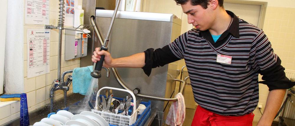 Altenhelfer Adam Chenaoui absolviert sein FSJ Hauswirtschaft im Seniorencentrum St. Konrad der CARITAS in Berlin-Köpenick; fotografiert beim Abwaschen in der Küche.