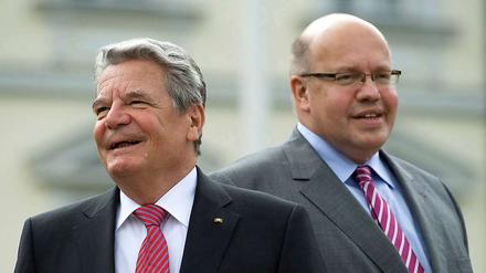 Joachim Gauck (links) bedankt sich auf seine Weise bei der FDP dafür, dass die Partei ihn zum Bundespräsidenten befördert hat. Umweltminister Peter Altmaier (CDU) sieht das mit eher gebremster Begeisterung. 