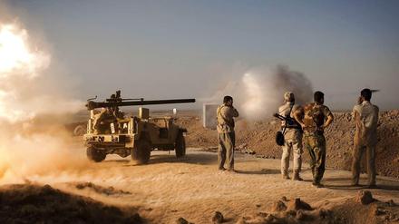 Kurdische Peschmerga-Kämpfer feuern in Richtung von IS-Stellungen. 