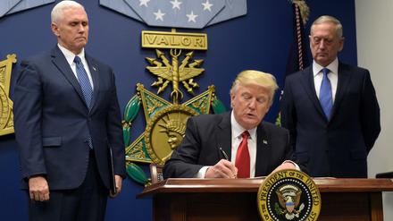 Mit Signatur und Siegel. Donald Trump unterschreibt neben Verteidigungsminister James Mattis (r) und Vizepräsident Mike Pence (l) im Pentagon sein Exekutiv-Dekret, mit dem der Zustrom von Flüchtlingen verringert werden soll. 