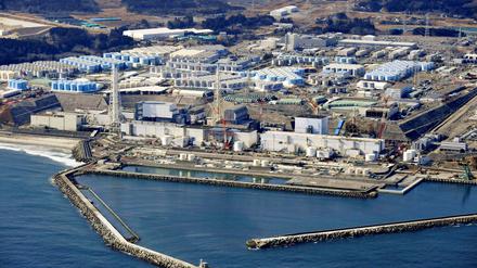 Blick auf das zerstörte Atomkraftwerk in Fukushima mit Tanks für kontaminiertes Wasser