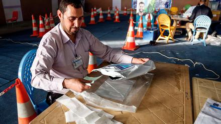 Ein Mitglied der irakischen Wahlkommission vergleicht die Stimmzettel mit den elektronischen Print-outs der Zählmaschine.  