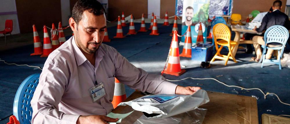 Ein Mitglied der irakischen Wahlkommission vergleicht die Stimmzettel mit den elektronischen Print-outs der Zählmaschine.  