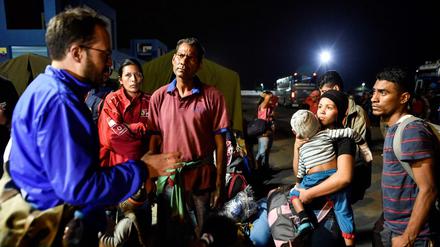 Ein UNHCR-Beamter spricht in Ecuador mit Flüchtlingen aus Venezuela. 