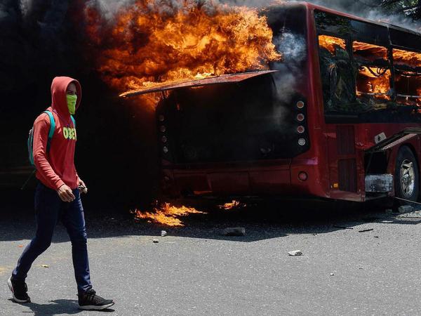 In der Nähe des Luftwaffenstützpunkts von Caracas warfen Demonstranten Molotow-Cocktails. Ein Bus brannte aus.