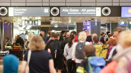 Reisende stehen am 7. Juli in Schlangen an der Sicherheitskontrolle am Hamburger Flughafen.