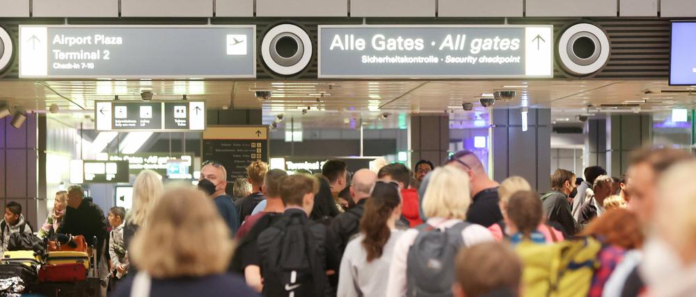Reisende stehen am 7. Juli in Schlangen an der Sicherheitskontrolle am Hamburger Flughafen.