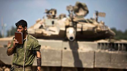Ein israelischer Soldat betet vor einem Panzer im Gazastreifen, aufgenommen am Donnerstag den 24. Juli. 