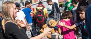 Eine freiwillige Helferin verteilt am Münchner Hauptbahnhof Stofftiere an Flüchtlingskinder.