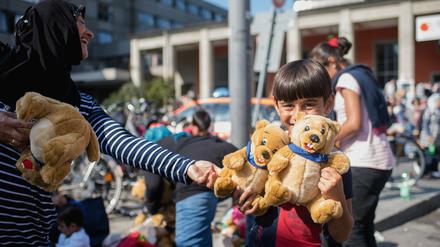 Ein Flüchtlingskind freut sich am am Hauptbahnhof von München über geschenkte Stofftiere.