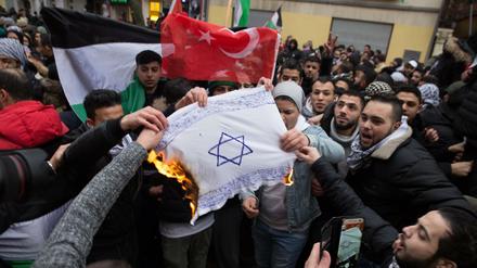 Antisemitismus auf der Straße: Teilnehmer einer Demonstration verbrennen eine selbstgemalte Fahne mit einem Davidstern in Neukölln.