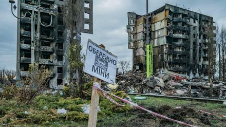 Ein Schild warnt in einem zerbombten Wohngebiet nahe Kiew vor Minen.