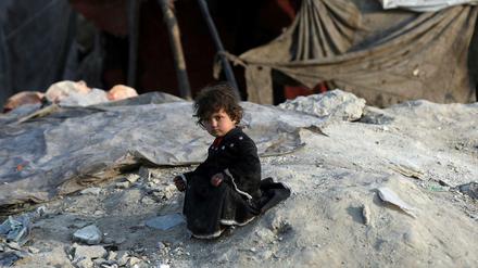 Ein mit ihrer Familie vertriebenes Mädchen sitzt außerhalb einer provisorischen Unterkunft in Kabul.