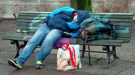 Ein Obdachloser schläft in einem Berliner Park auf einer Bank. Die Berliner Armut verbirgt sich aber meistens, denn am stärksten von Armut bedroht sind Alleinerziehende und Kinder. 
