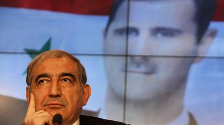 Vize-Regierungchef Kadri Dschamil vor einem Porträt Baschar al-Assads: Ist der syrische Präsident zum Rückzug bereit? 