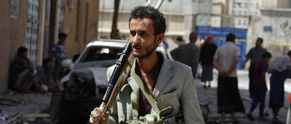 Ein Kämpfer der Huthi-Rebellen inspiziert den Ort eines Autobombenanschlags in der jemenitischen Hauptstadt Sanaa.