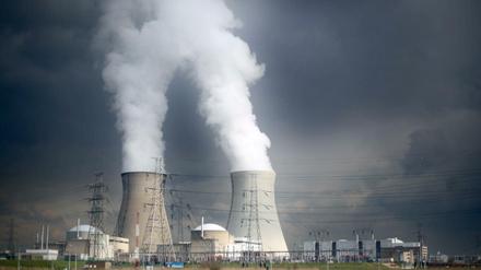 Dampf steigt hinter einer Windmühle bei Antwerpen (Belgien) aus den Kühltürmen des Atomkraftwerks Doel.
