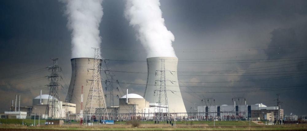 Dampf steigt hinter einer Windmühle bei Antwerpen (Belgien) aus den Kühltürmen des Atomkraftwerks Doel.