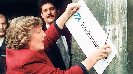 Die scheidende Treuhand-Präsidentin Birgit Breuel entfernt 30.12.1994 das Firmenschild in Berlin.