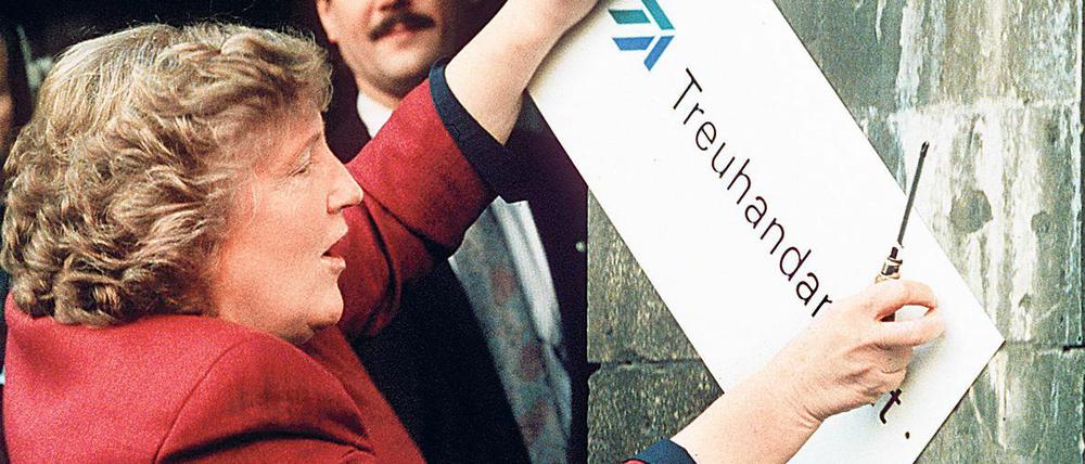 Die scheidende Treuhand-Präsidentin Birgit Breuel entfernt 30.12.1994 das Firmenschild in Berlin.
