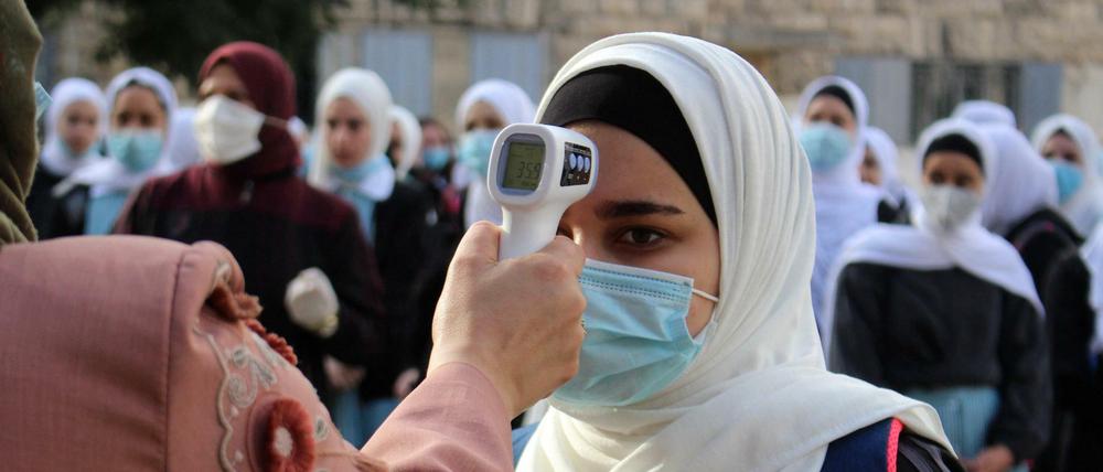Prüfen, bitte! Bei einer palästinensischen Schülerin wird die Temperatur gemessen.