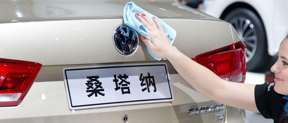  Eine Frau säubert auf dem Messestand von Volkswagen bei der Auto China im chinesischen Peking das Emblem eines Volkswagen Santana.