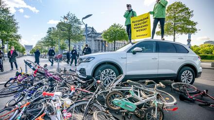 Aktivisten von Greenpeace demonstrieren vor dem Reichstag mit einer Aktion, bei der ein Auto über Fahrräder fährt. Mit Protestaktionen soll gegen eine erneute Abwrackprämie für Diesel und Benziner demonstriert werden.