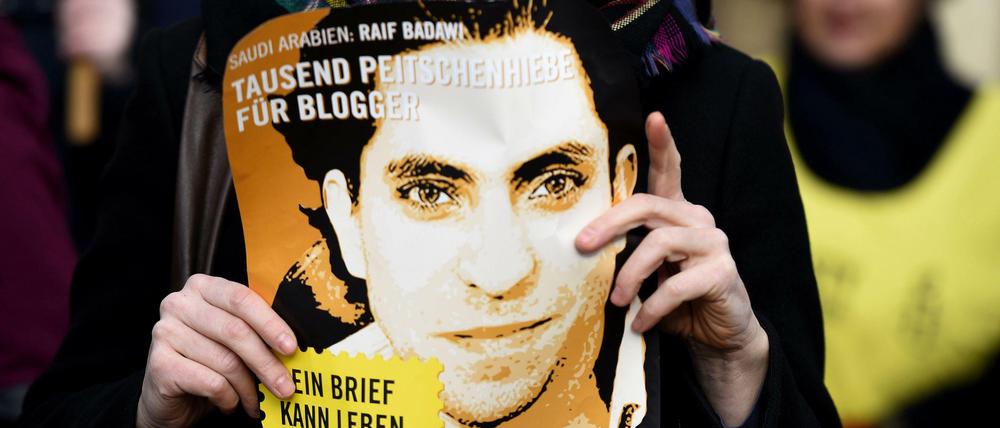 Eine Frau mit einem Plakat Raif Badawis bei einer Protestveranstaltung in Berlin