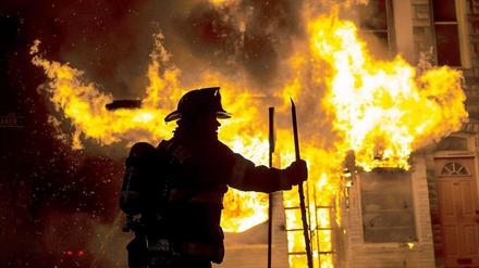 Ein Feuerwehrmann vor einem in Brand gesteckten Gebäude in Baltimore.