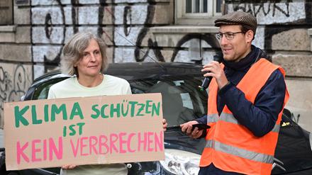 Ein Angeklagter (r) im Prozess gegen zwei Klimaschützer nach Straßenblockaden in Stuttgart spricht bei einer Kundgebung vor dem Gerichtsgebäude (Archivbild).