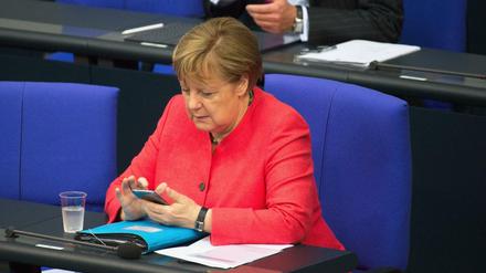 Das Mobiltelefon im Blick: Bundeskanzlerin Angela Merkel im Bundestag (Archivbild)
