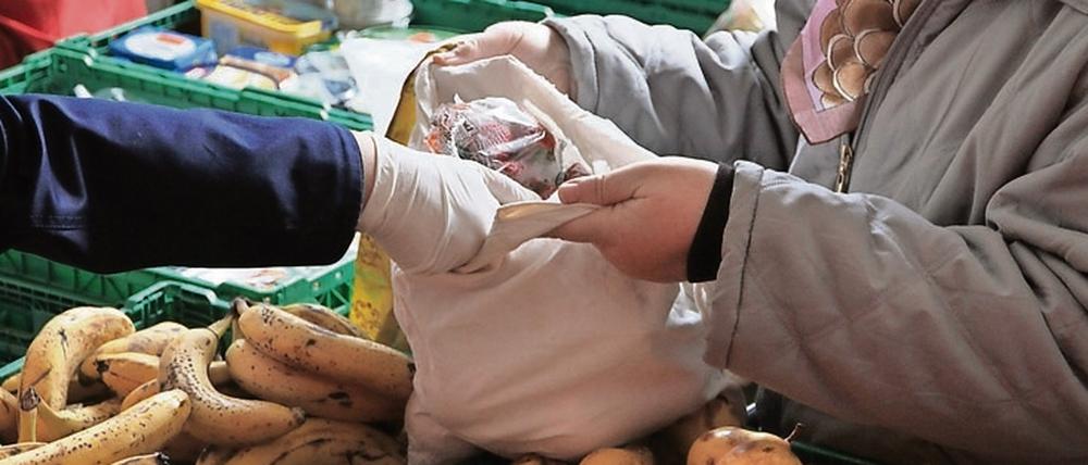 Eine Mitarbeiterin der Berliner Tafeln verteilt in Berlin Obst an Bedürftige.