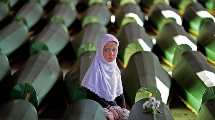 Ein Mädchen sitzt im Potocari Memorial Center an einem der 173 Särge mit Opfern aus Srebrenica, die zuletzt identifiziert worden waren. 